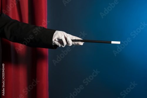Tableau sur toile Magician showing trick with wand on stage, closeup