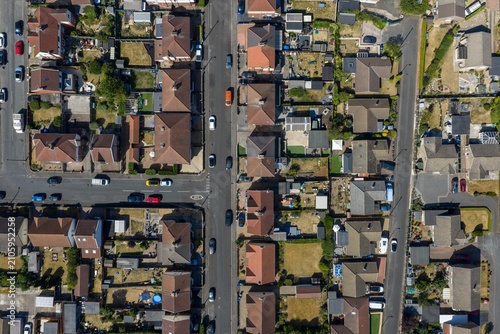 Vertical aerial photo above a residential neighbourhood in Mexborough South Yorkshire England showing detached homes gardens busy roads and suburban streets captured from a drone on a sunny summer day