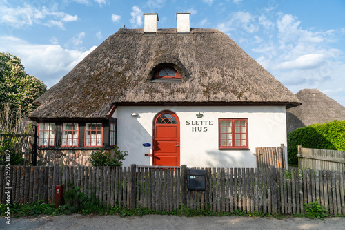 Принти на полотні Traditionelles dänisches Bauernhaus mit Reetdach unter blauem Himme