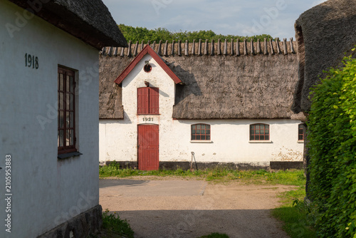Traditionelles dänisches Bauernhaus mit Reetdach unter blauem Himme