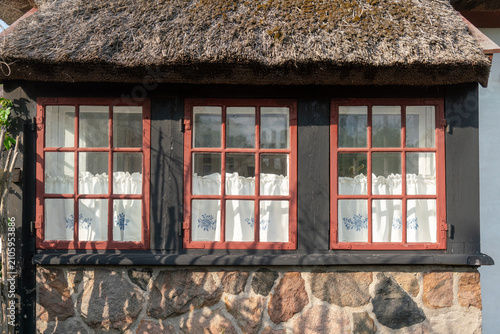 Traditionelles dänisches Bauernhaus mit Reetdach unter blauem Himme