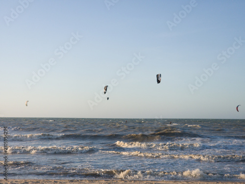 Multiple kitesurfers ride the waves off Cumbuco beach, a world renowned kite spot in Brazil.