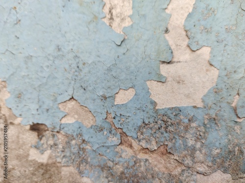A distressed wooden surface featuring random peeling paint, chipped layers, cracks, scratches, and naturally weathered wood grain. The irregular worn texture creates a rustic, vintage, and aged appear