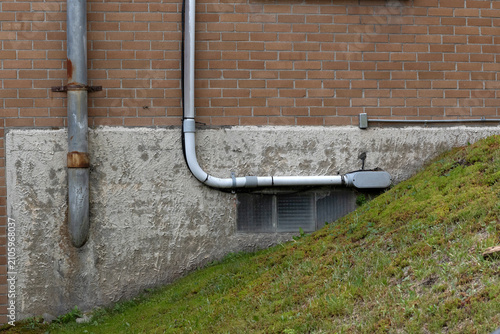 Canvas Print Metal and plastic piping on a brick wall