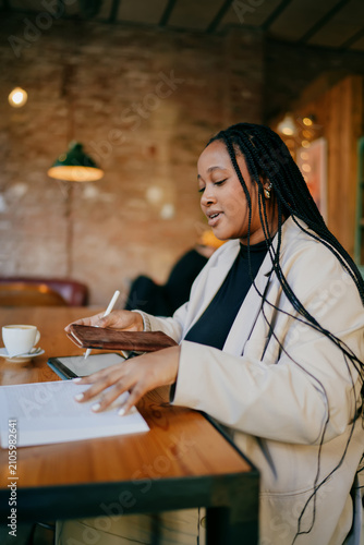 Photography Pensive woman professional flipped book page working on tablet, female entrepreneur using digital stylus for project research at cafe, nomadic lifestyle and remote education concept, indoor