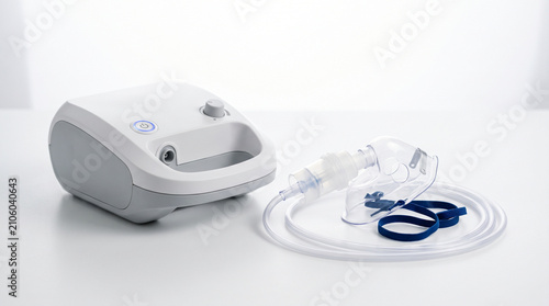 Compressor nebulizer machine with inhalation mask on white table