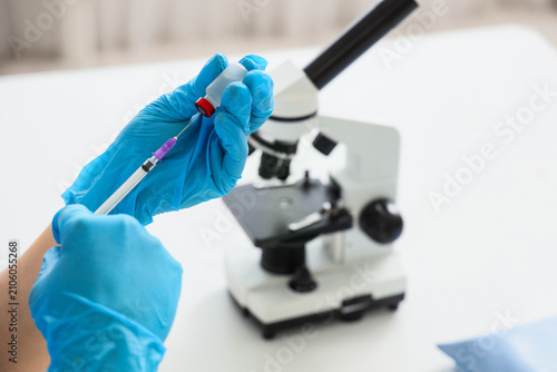 Scientist in blue gloves pr...