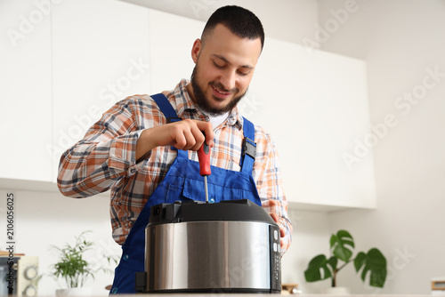 Smiling young repairman in ...