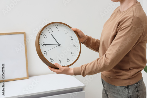 Woman with wall clock at ho...