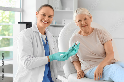 Senior woman with doctor vaccinating in clinic