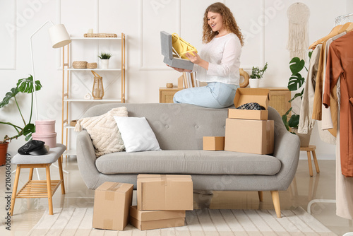 Young woman unpacking box w...