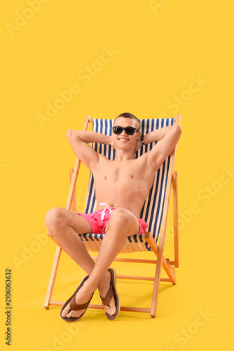 Teenage boy in deck chair o...