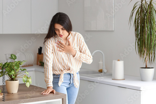 Young woman having panic attack in kitchen