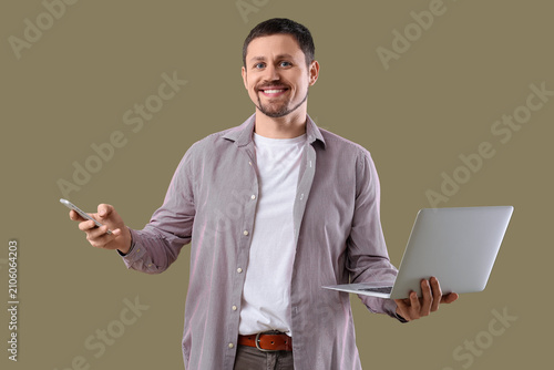 Man with laptop on color  b...