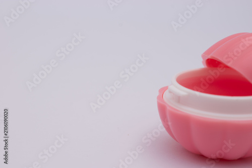 Pink lipstick with daisy flower on pastel background