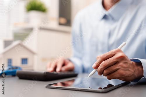 Digital signature and asset management concept. Man signing on tablet.