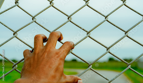 Quadro su tela Man hand holding metal chain link fence