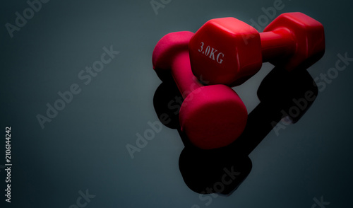 Foto Red dumbbells isolated on black background