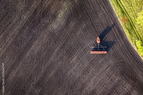 Фотография Seeding equipment working on plowed agricultural field with copy space, soil pre