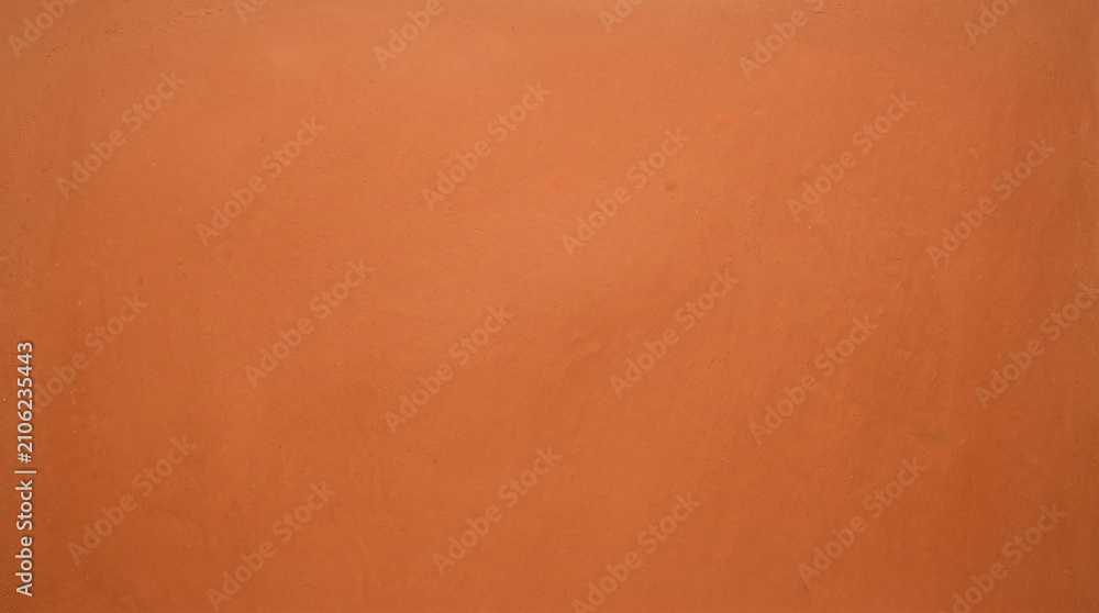 Fototapeta premium Vibrant orange smooth plaster wall texture background for bold warm design