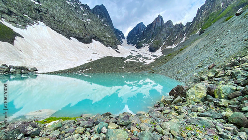 Bild auf Leinwand White Abudelauri Lake reflects snowbound Chaukhi peaks in Georgia, combining tur