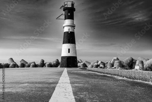 Bild auf Leinwand Lighthouse stands tall, bold against stormy skies