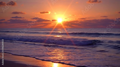 Golden sun rays shine over the ocean waves at sunrise