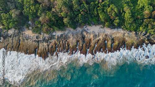 фотографія Aerial coastal waves with lush forest, symbolizing summer paradise, travel freedom, and untouched natural beauty