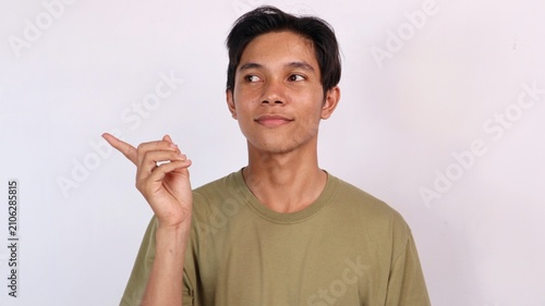 Fotografía young asian man pointing and glancing sideways