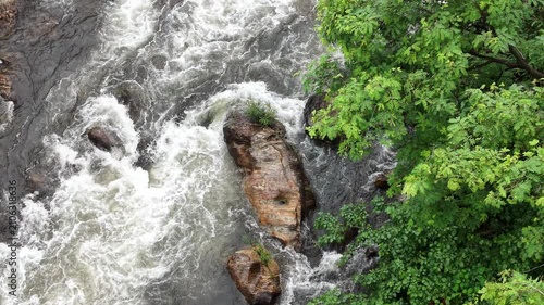 River water rushing over rocks through dense green tropical forest