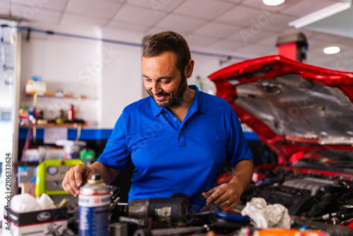 Mechanic smiling while working in auto repair shop