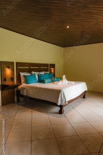 Bild auf Leinwand Hotel room interior featuring bed with decorative pillows and towel art