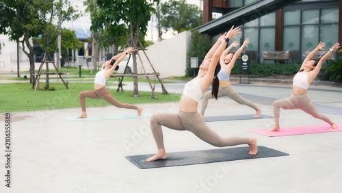 Obraz na plátně Healthy Asian women group practicing advanced acro yoga and flexibility poses outdoors