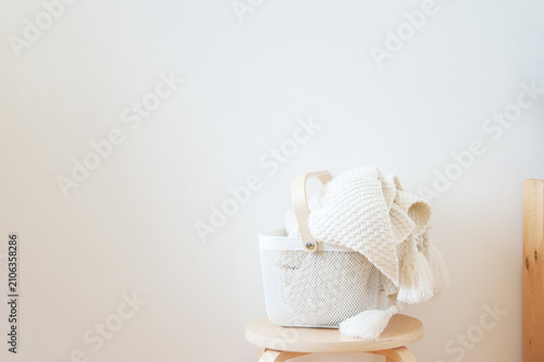 Fotografía White laundry basket with blankets in minimalist room corner