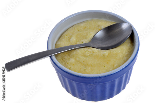 Mousse au citron vert maison dans un ramequin avec une cuillère en gros plan isolée sur fond blanc