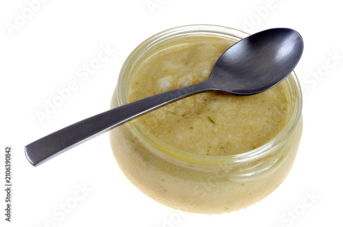 Mousse au citron vert maison dans un ramequin avec une cuillère en gros plan isolée sur fond blanc