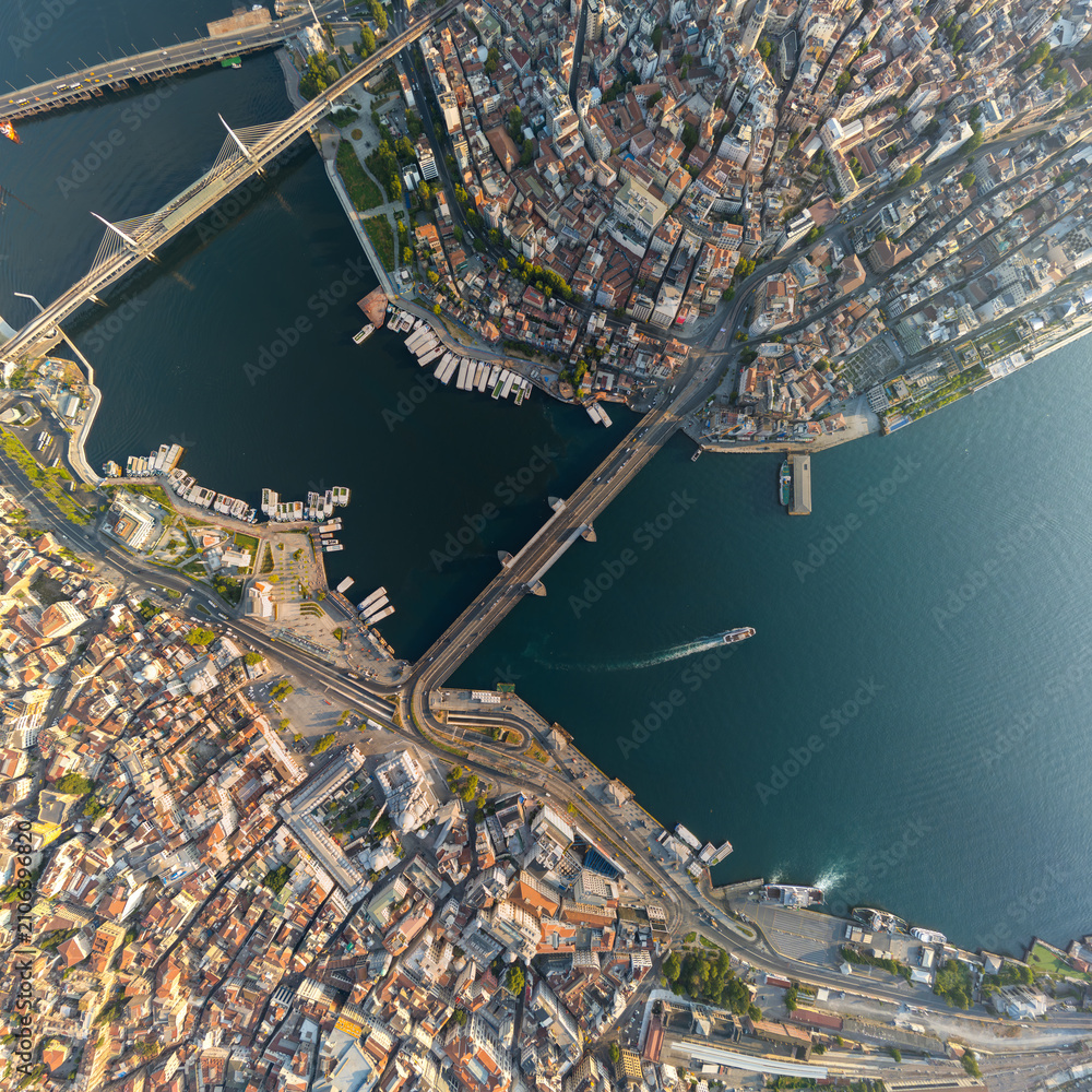 Fototapeta premium Istanbul, Turkey. Top-down aerial view of Galata Bridge over Golden Horn, Bosphorus strait, Halic Metro Bridge, and districts from above. Aerial view