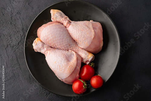 Raw chicken leg or drumstick isolated on black  background 