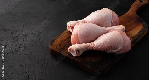 Raw chicken leg or drumstick isolated on black  background 