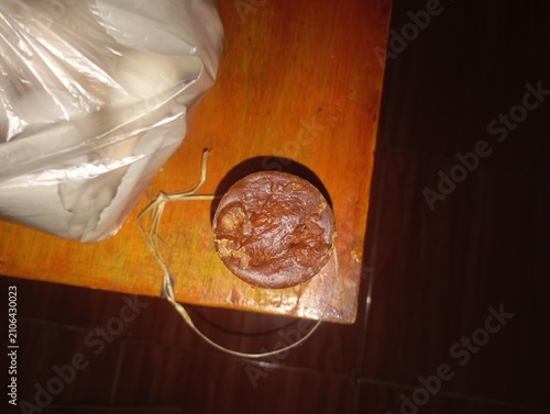 Fotografie A round piece of traditional brown sugar block sitting on a wooden table surface