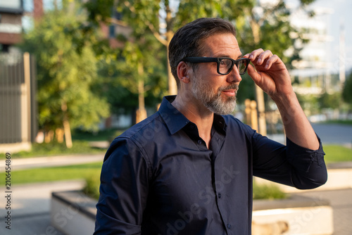 Caucasian man using AR glasses in city park with futuristic technology