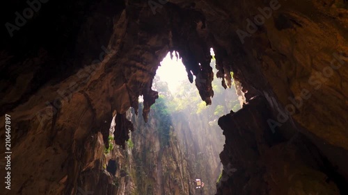 Rays of sunlight entering Batu Caves at Kuala Lumpur, Malaysia. Ancient limestone formation at opening of cave. Famous landmark of Malaysia.  Travel and holidays concept. 