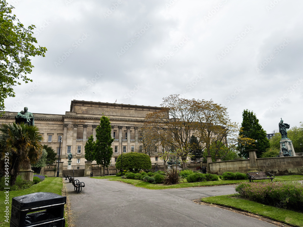 Fototapeta premium Overcast day in a formal park with historic neoclassical building and statues near St Georges Hall, Liverpool, UK