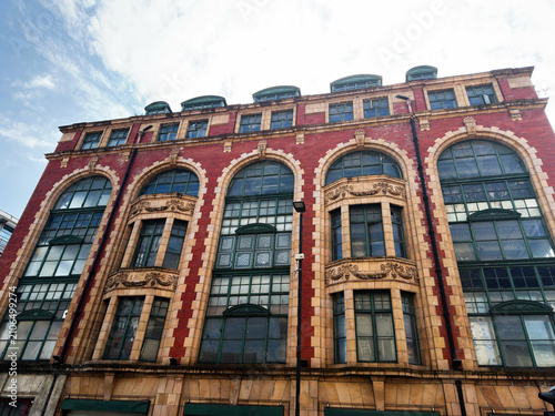Fotografía Historic redbrick building facade with arched windows and decorative stonework i