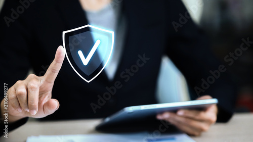 Businesswoman Touching Security Shield Icon with Tablet for Cyber Data Protection Concept