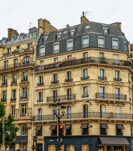 Haussmann architecture shaping Paris cityscape, old building facades with mansard roofs, windows, and balconies