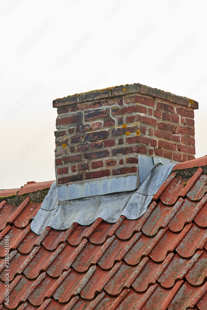 Obraz premium Brick, chimney and roof of house, architecture or outdoor with weathered residential structure. Building, home and ventilation for air pollution with tiles, rustic and space on white background