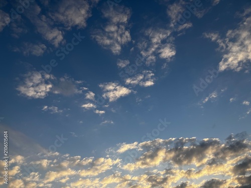 Bild auf Leinwand Golden twilight clouds glowing along the horizon under a navy blue sky