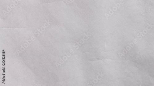 Abstract crumpled paper texture background with soft lighting. Minimal clean surface for design, presentations, typography, overlay and motion graphics. Seamless looping 4k