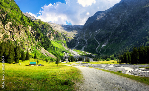 Obraz na plátne Austrian Alps with snow-capped peaks, lush green valleys, and a small mountain v